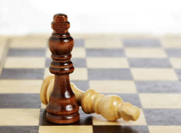 Close up of checkmate wooden pieces on board — Stock Photo, Image