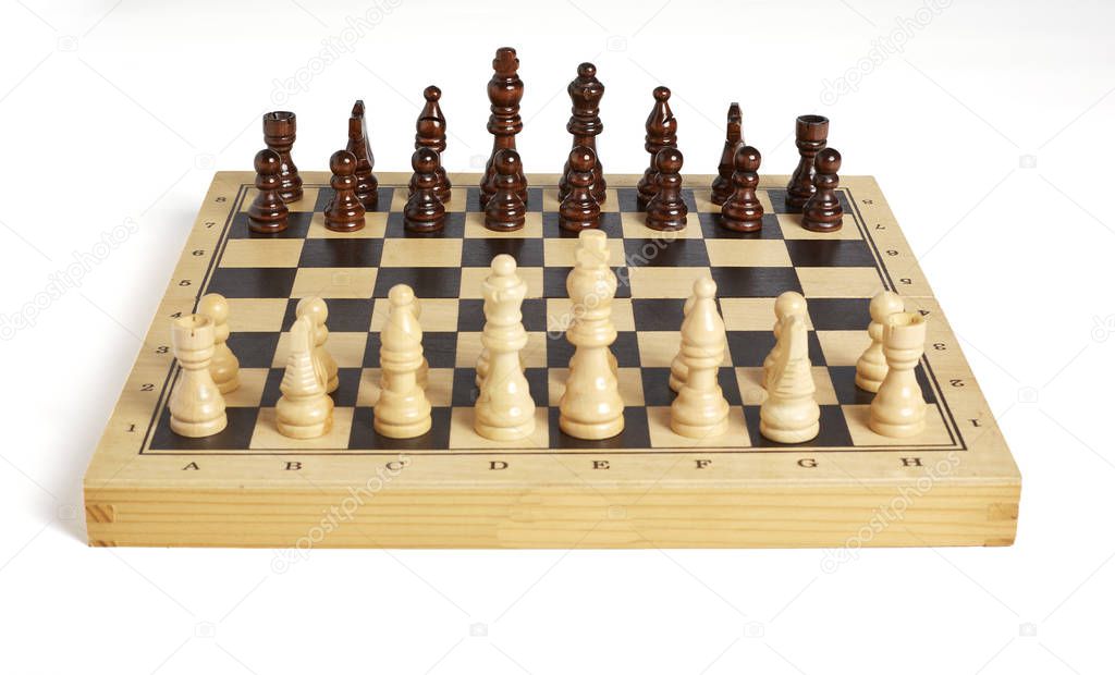 Wooden chess pieces on board frontal view