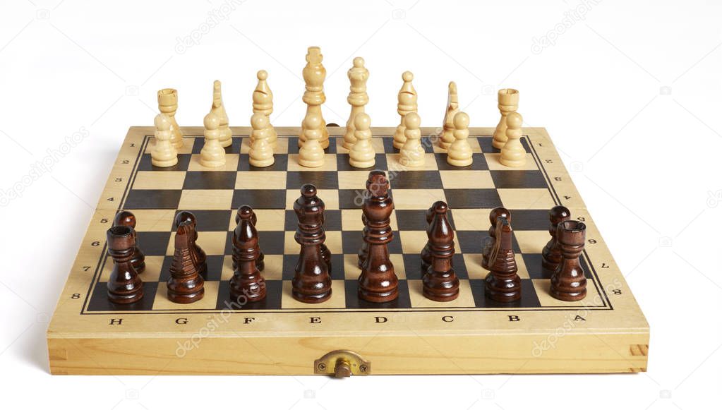 Wooden chess pieces on board frontal view
