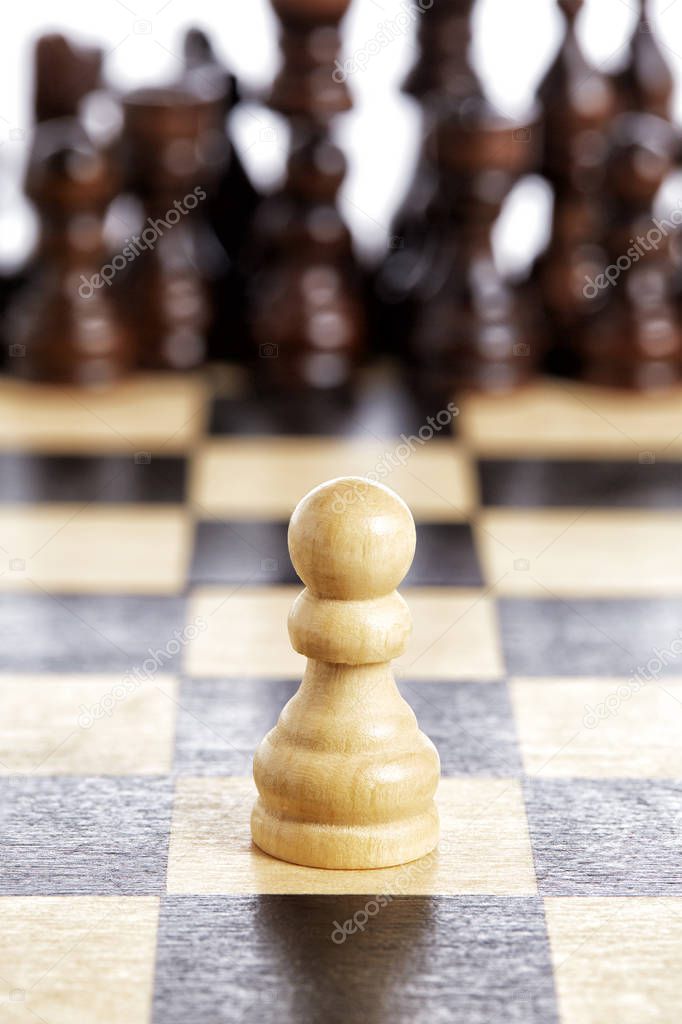 Wooden pawn chess piece white on chessboard