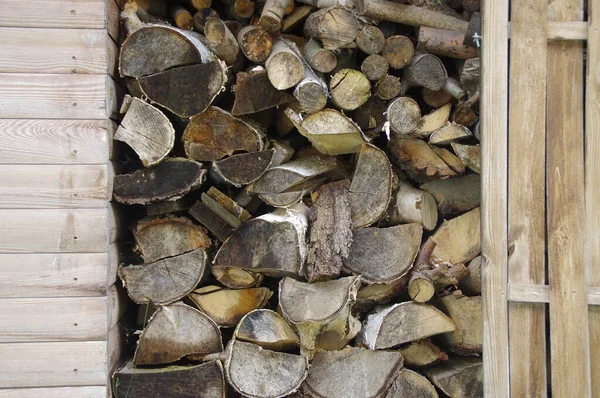 Stocks of wood for the fireplace. Heap of chopped pieces of trees. Natural fuel for winter.