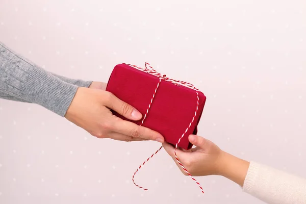 Mãos de um adulto dando um presente a uma criança. Natal, Ano Novo, Aniversário — Fotografia de Stock