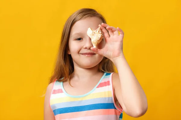 Holčička drží mušli. Closeup dítě v letních šatech na žlutém pozadí — Stock fotografie