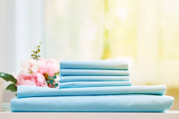 Masadaki mavi temiz yatak yığınını kapatın. Bulanık arka plan — Stok fotoğraf