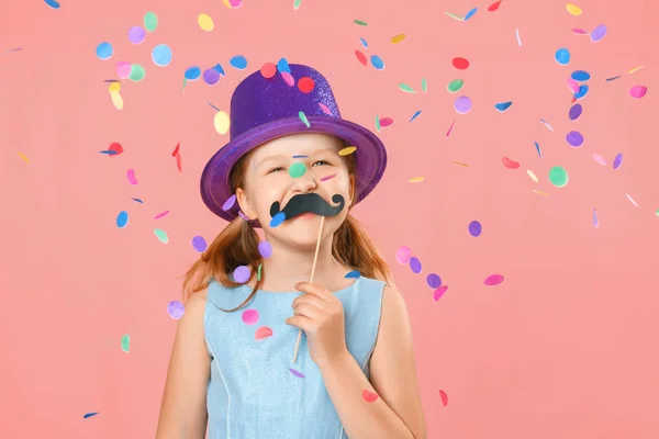 Happy father's day. Funny little girl with fake mustache and wearing a hat under falling confetti on a pink background. Family concept — Stock Photo, Image