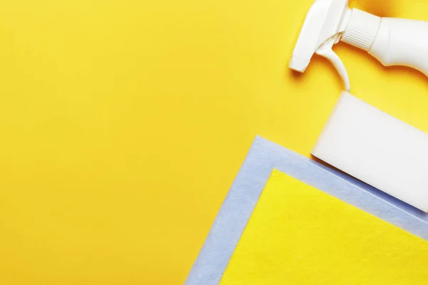 用洗涤剂、海绵和餐巾纸在黄色背景上喷洒瓶子. 清洗概念 — 图库照片