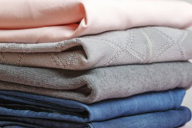 Mavi, pembe ve gri renkli katlanmış giysiler yığını. Yakın plan.