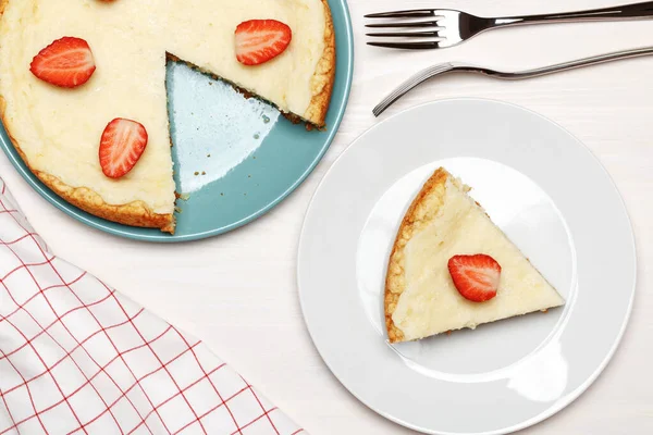 Klassisk cheesecake med jordbær på hvid baggrund. Et stykke på en tallerken. Set fra oven - Stock-foto