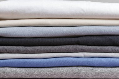 Bir yığın katlanmış kıyafet. Kapat.