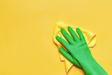 Renkli arka planda sarı peçeteli yeşil eldiven. Temizlik kavramı