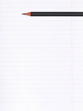 Üzerinde çizgiler olan bir kağıt defter üzerinde siyah bir grafit kalem bulunur. Uzayı kopyala Eğitim kavramı
