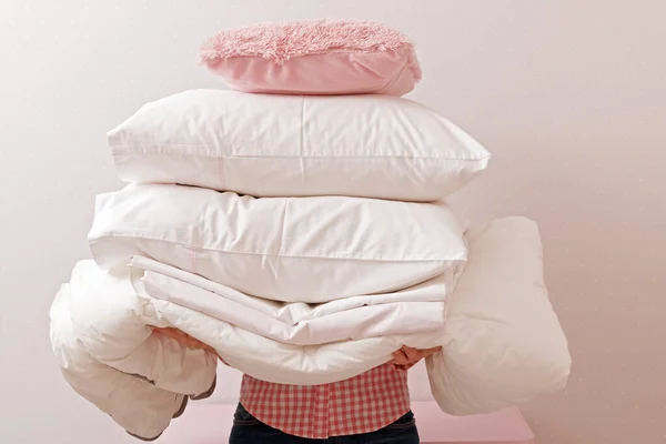 Mujer sosteniendo una pila de ropa de cama para dormir. Hogares —  Fotos de Stock