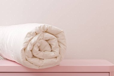 Dolabın üstünde sarılı bir yorgan var. Yatak için battaniye.