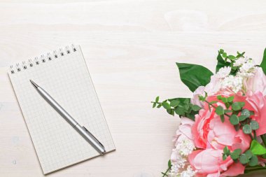 Boş not defteri ve mürekkep kalemi olan çiçek.