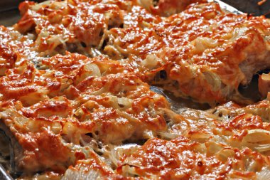 Fırın tepsisinde doğranmış soğan ve peynirli fırında et. Yemek dokusu ve geçmişi. Yakın çekim.