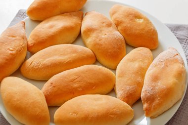 Yakın plan, ev yapımı yemek. Küçük turtalar beyaz bir tabakta yatıyor.