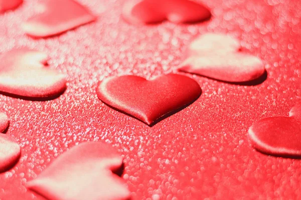 Розташування червоного серця на блискучому червоному тлі. Святкування Дня Валентина. Вибіркове зосередження — стокове фото