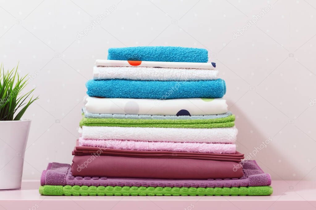 On the dresser there is a stack of clean ironed bed linen, folde