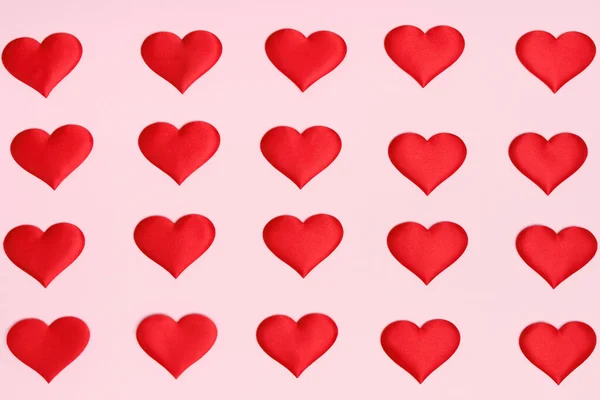 Día de San Valentín. Suavizar incluso filas de corazones rojos sobre un fondo rosa. Acostado. Vista superior. Concepto mínimo —  Fotos de Stock