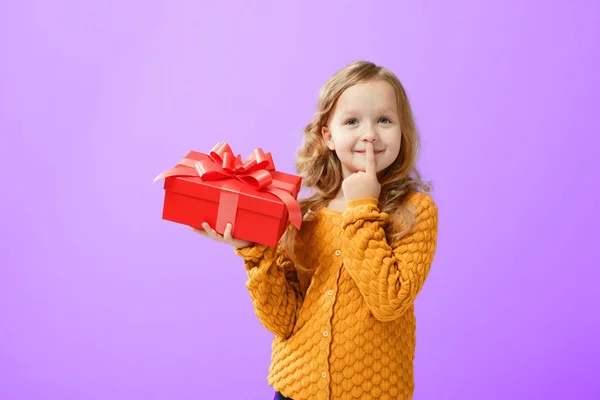 Ritratto di una bambina in un maglione caldo su un protone viola b — Foto Stock