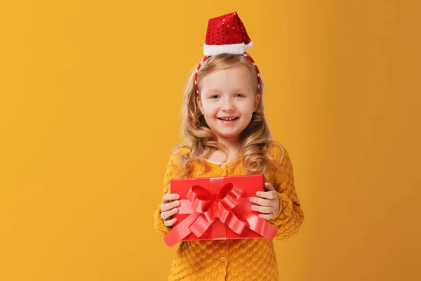 Niña feliz en un suéter y gorra de punto caliente Santa — Foto de Stock