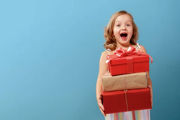 Felice bambina bionda in possesso di tre scatole con regali su — Foto Stock