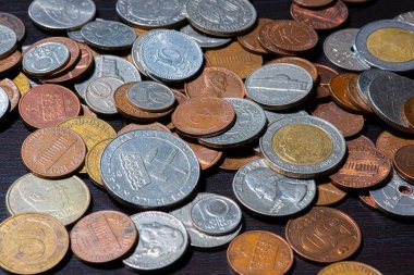 Siyah bir masada farklı madeni paralar..