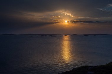 Denizin üzerinde parlayan gün batımı.