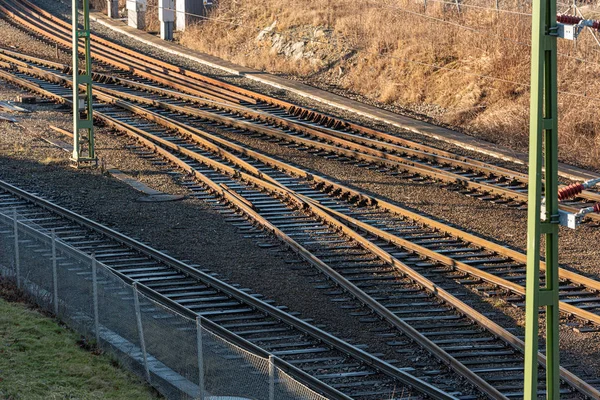 Parallell railway tracks in low sunlight.