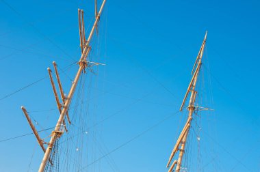 Gururlu bir yelkenlinin çıplak direkleri.