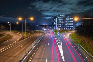 Gece otoyol trafiğine uzun süre maruz kalmışsın. İnşaat halindeki bir binayla kavşak..