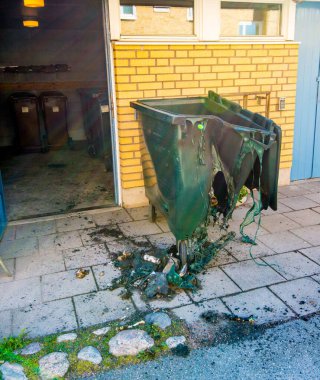 Yeşil çöp konteyneri tek kullanımlık barbekü ile eritilmiş..