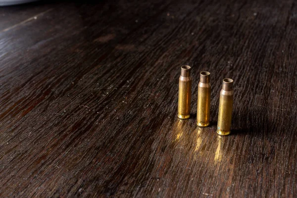 暗い木製のテーブルの上に空の弾丸のケーシング — ストック写真