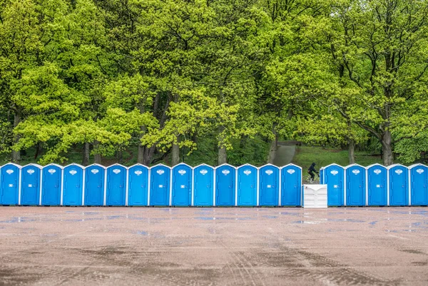 森の前に長い列のポータブルトイレがあります — ストック写真