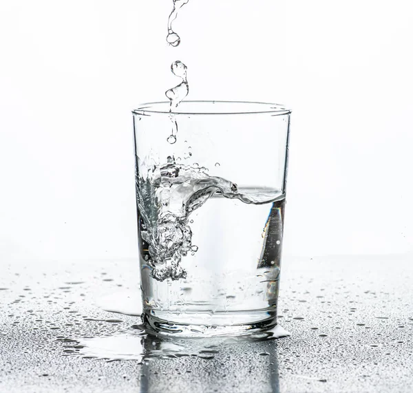 Água Sendo Derramada Copo Fundo Branco — Fotografia de Stock