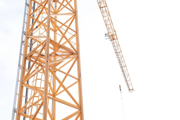 Alto, guindaste de construção amarelo contra um céu branco .. — Fotografia de Stock