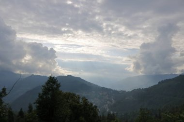 Yeşil ağaçlarla kaplı dağ manzarası ve Hindistan 'ın Sikkim şehrinde ağır bulutlu gökyüzü olan bitkiler