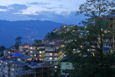 Gangtok, Sikkim, Hindistan 'da evleri olan dağların ve küçük kasabaların gece manzarası.