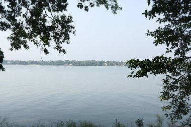 Gün batımında Ganga nehri üzerinde ağaçlarla akan sular.