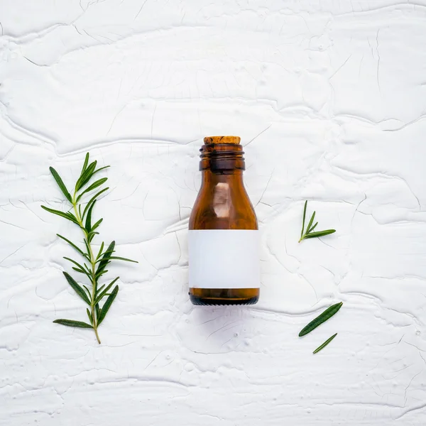 Fresh branch of rosemary  with bottle essential oil setup on whi — Stock Photo, Image