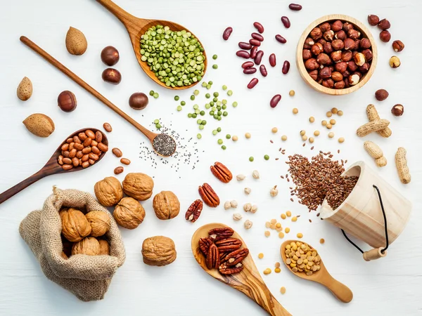 Bowls and spoons of various legumes and different kinds of nuts — Stock Photo, Image