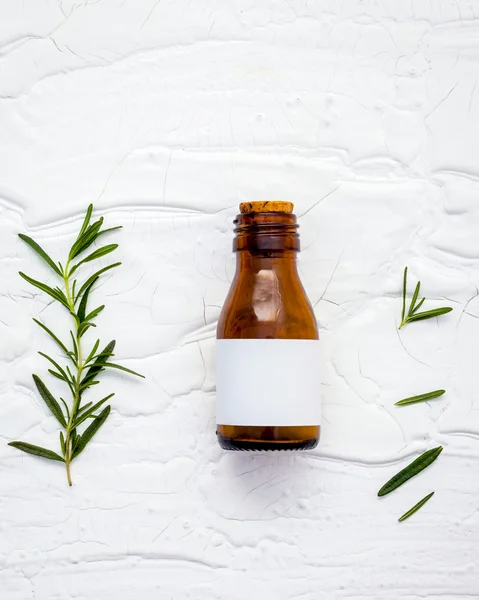 Fresh branch of rosemary  with bottle essential oil setup on whi — Stock Photo, Image