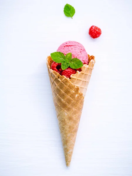 Raspberry ice cream in cone with fresh raspberry and peppermint