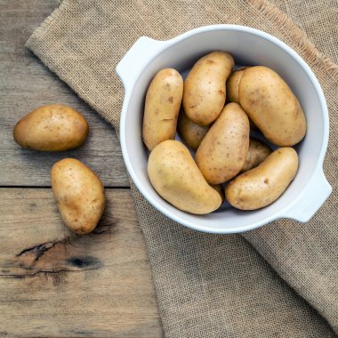 H üzerinde beyaz seramik kase taze organik patates bileşimi