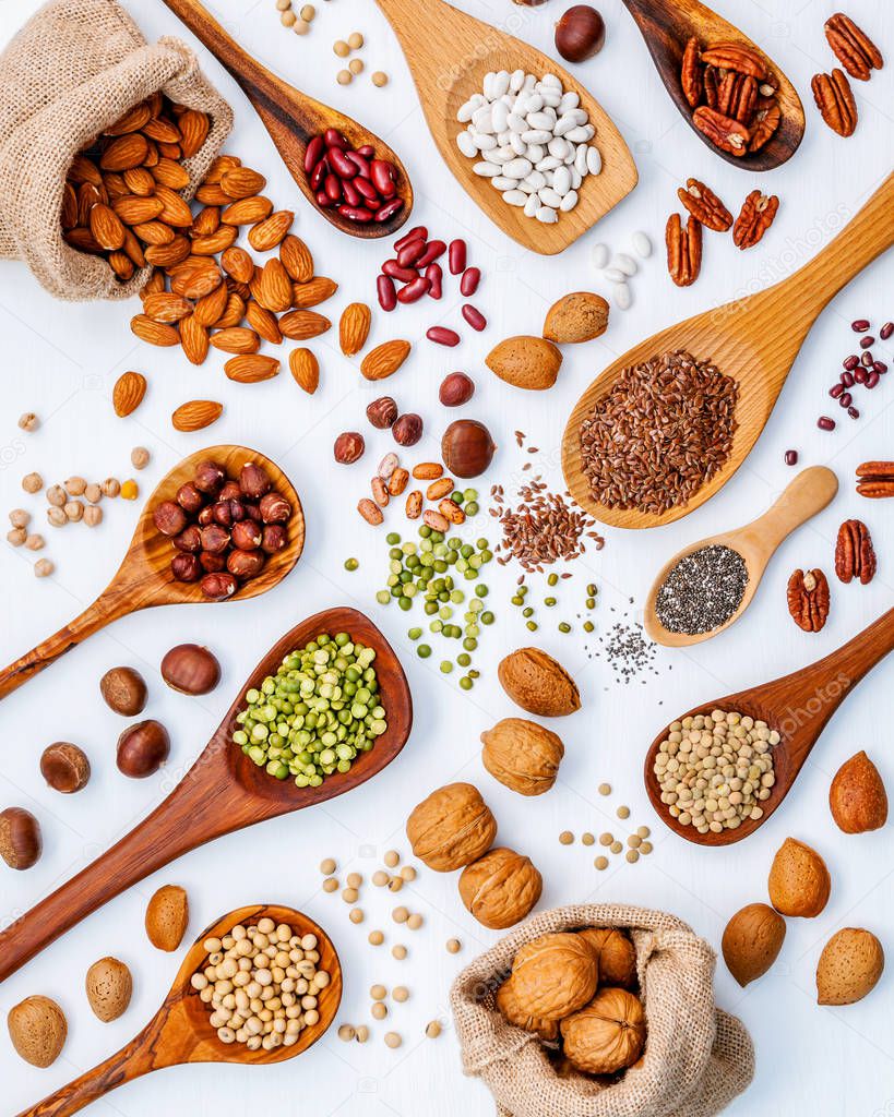 Various legumes and different kinds of nuts in spoons. Walnuts k