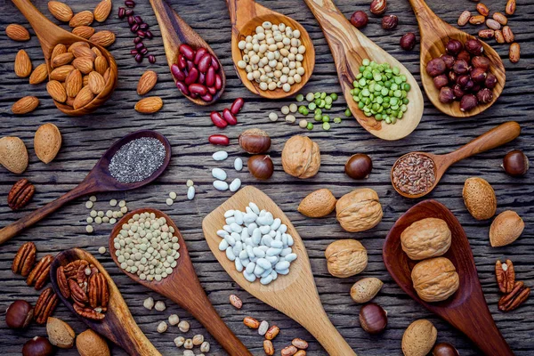 Varias legumbres y diferentes tipos de cáscaras de nuez en cucharas. Waln. — Foto de Stock