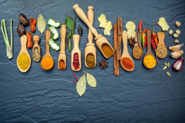 Çeşitli baharat ve otlar tahta kaşıklar. Baharatlar düz yatıyordu