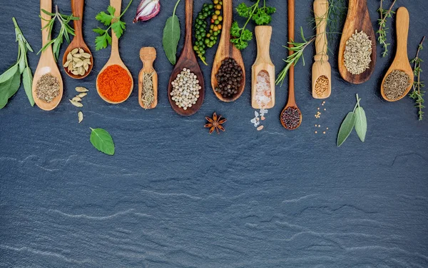 Varias especias y hierbas en cucharas de madera. Puesta plana de especias — Foto de Stock