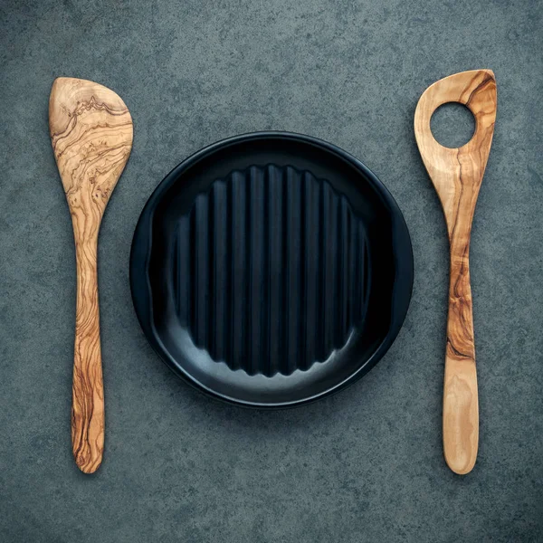 Tahta kaşık mutfak aletleri tahta spatula ve siyah plaka o — Stok fotoğraf