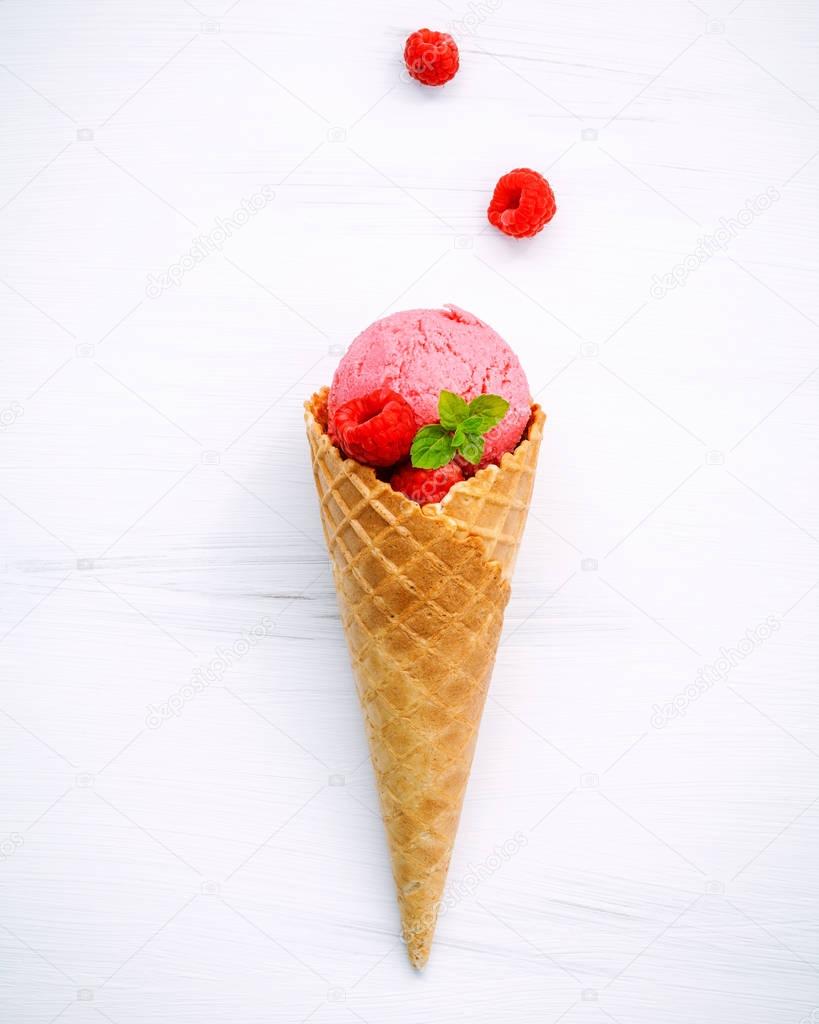 Raspberry ice cream in cone with fresh raspberry and peppermint 
